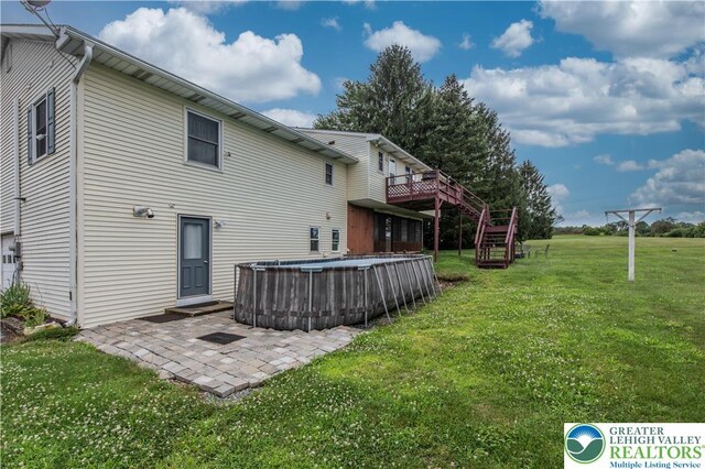 8555 Mohr Ln, Weisenberg Twp, PA 18051 - rear view of property with stairs, an outdoor pool, a yard, a patio area, and a deck