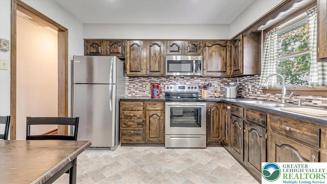 5129 3rd St, Whitehall Twp, PA 18052 - kitchen featuring stainless steel appliances, dark countertops, tasteful backsplash, and dark brown cabinets