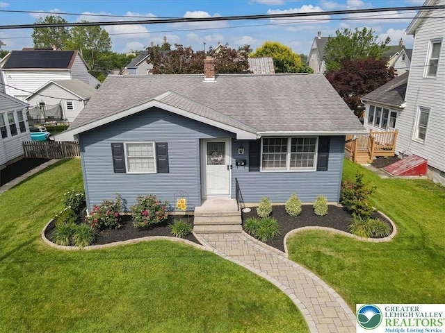 5129 3rd St, Whitehall Twp, PA 18052 - view of front of home featuring a shingled roof, a front lawn, and a chimney