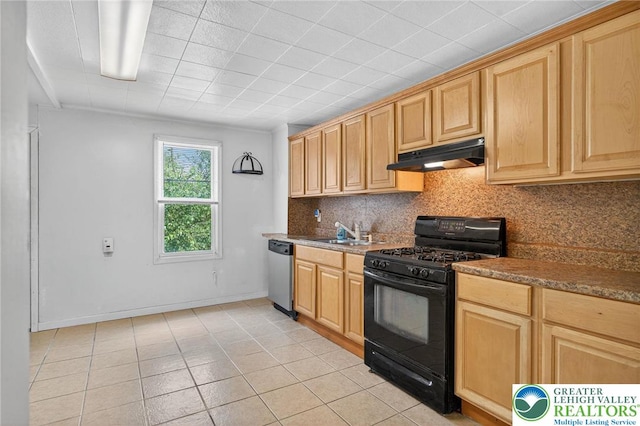 22 N Warren St, Easton, PA 18042 - kitchen with black gas range oven, under cabinet range hood, stainless steel dishwasher, tasteful backsplash, and light tile patterned flooring