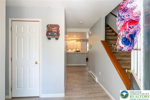 2175 Village Rd, Chestnuthill Twp, PA 18330 - hall featuring a baseboard heating unit, stairs, and wood finished floors