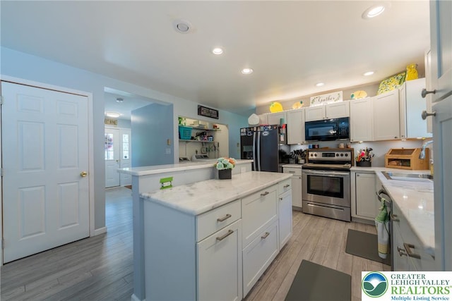 2175 Village Rd, Chestnuthill Twp, PA 18330 - kitchen featuring black appliances, a kitchen island, light wood finished floors, recessed lighting, and white cabinets