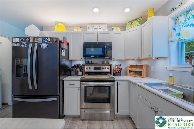 2175 Village Rd, Chestnuthill Twp, PA 18330 - kitchen featuring black microwave, fridge with ice dispenser, stainless steel range with electric cooktop, light countertops, and light wood-style flooring