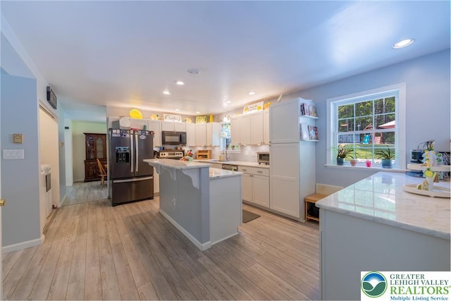 2175 Village Rd, Chestnuthill Twp, PA 18330 - kitchen with stainless steel refrigerator with ice dispenser, black microwave, light stone countertops, a center island, and white cabinetry