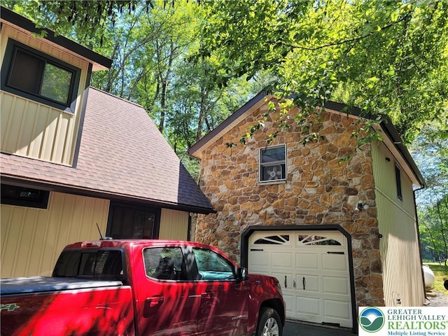 2048 Beaver Run Rd, Tobyhanna Twp, PA 18347 - view of side of property featuring stone siding, a shingled roof, a garage, and board and batten siding