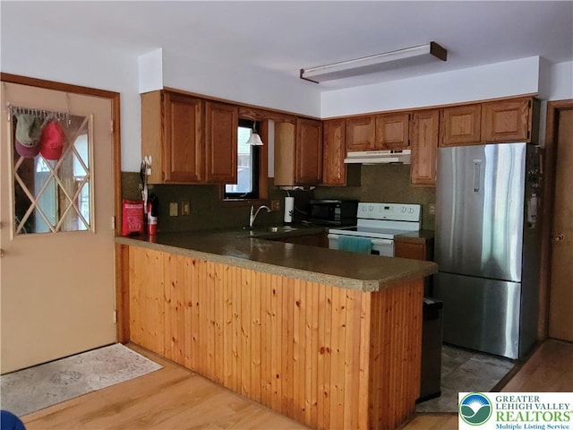 2048 Beaver Run Rd, Tobyhanna Twp, PA 18347 - kitchen featuring electric range, freestanding refrigerator, black microwave, under cabinet range hood, and a peninsula