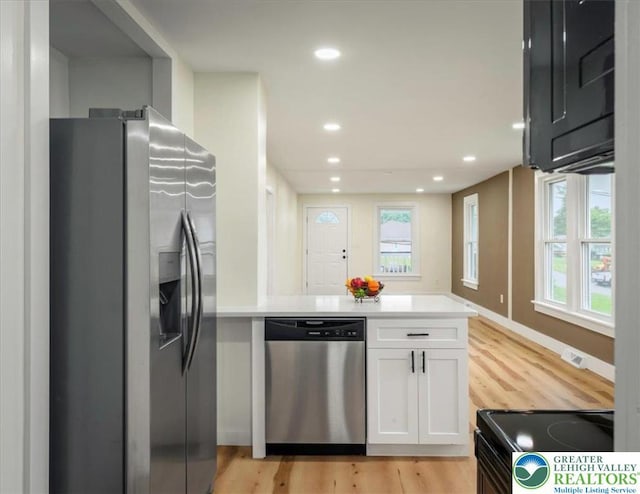 428 Shook Ave, Stroud Twp, PA 18360 - kitchen with stainless steel appliances, a peninsula, white cabinetry, light wood-type flooring, and light countertops