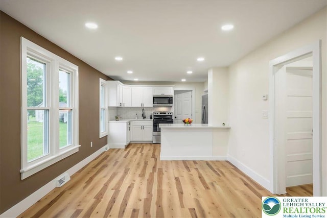 428 Shook Ave, Stroud Twp, PA 18360 - kitchen with appliances with stainless steel finishes, light countertops, light wood-style flooring, white cabinets, and recessed lighting