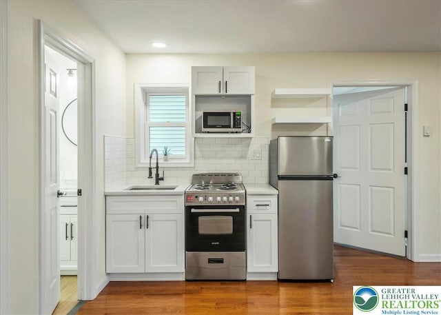428 Shook Ave, Stroud Twp, PA 18360 - kitchen featuring appliances with stainless steel finishes, light countertops, decorative backsplash, dark wood finished floors, and open shelves