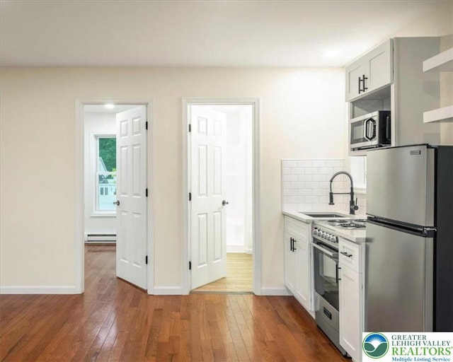 428 Shook Ave, Stroud Twp, PA 18360 - kitchen featuring stainless steel appliances, a baseboard heating unit, hardwood / wood-style flooring, and backsplash