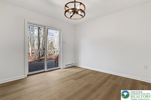 182 Maxatawny Dr, Coolbaugh Twp, PA 18347 - spare room with baseboard heating, a chandelier, and wood finished floors