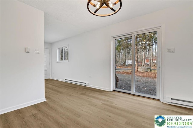 182 Maxatawny Dr, Coolbaugh Twp, PA 18347 - unfurnished room with a baseboard heating unit, healthy amount of natural light, and wood finished floors