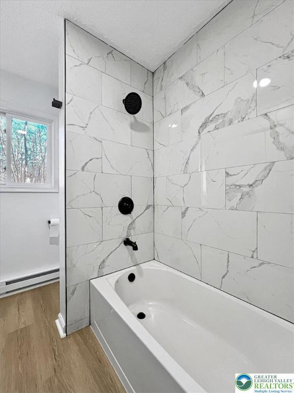 182 Maxatawny Dr, Coolbaugh Twp, PA 18347 - full bathroom with  shower combination, wood finished floors, a baseboard radiator, and a textured ceiling