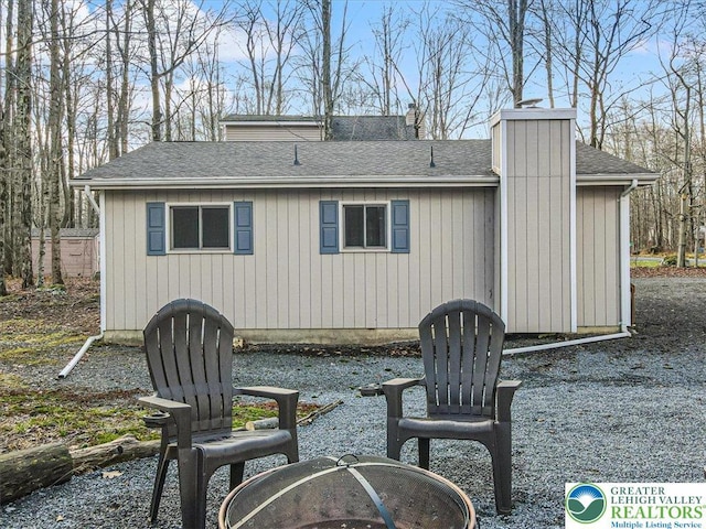 182 Maxatawny Dr, Coolbaugh Twp, PA 18347 - rear view of house featuring a shingled roof and a chimney