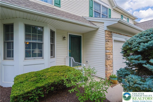 2877 Hope Ridge Dr, Bethlehem Twp, PA 18045 - property entrance with a shingled roof, an attached garage, and stone siding