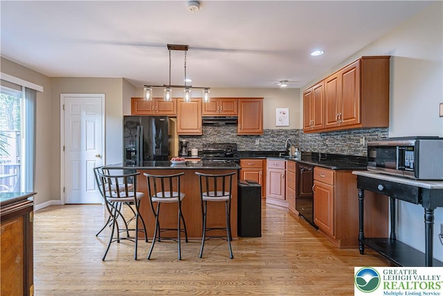 2877 Hope Ridge Dr, Bethlehem Twp, PA 18045 - kitchen with black appliances, under cabinet range hood, dark countertops, decorative backsplash, and recessed lighting