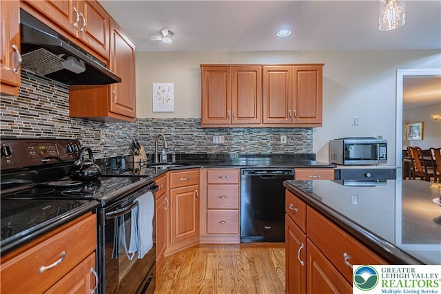 2877 Hope Ridge Dr, Bethlehem Twp, PA 18045 - kitchen with black appliances, under cabinet range hood, light wood-style floors, decorative backsplash, and brown cabinets