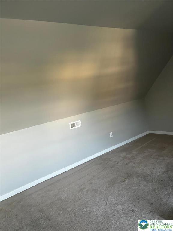 4954 Coatbridge Ln, Lehigh Twp, PA 18088 - additional living space featuring dark carpet and vaulted ceiling