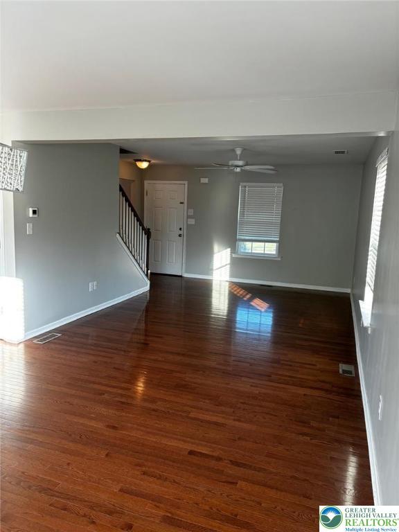 4954 Coatbridge Ln, Lehigh Twp, PA 18088 - unfurnished living room featuring stairs, plenty of natural light, wood finished floors, and ceiling fan