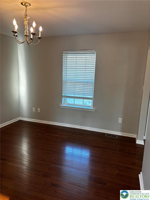 4954 Coatbridge Ln, Lehigh Twp, PA 18088 - spare room featuring a chandelier and dark wood-style flooring