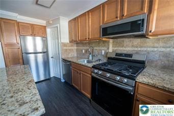 449 E Garrison St, Bethlehem City, PA 18018 - kitchen with appliances with stainless steel finishes, brown cabinetry, and decorative backsplash