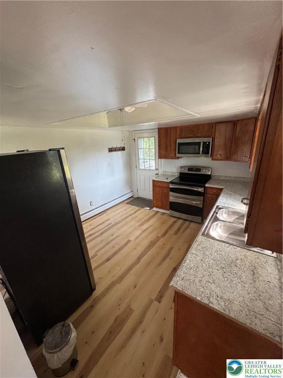 84 Moorestown Dr, Moore Twp, PA 18014 - kitchen featuring stainless steel appliances, baseboard heating, brown cabinets, and light countertops