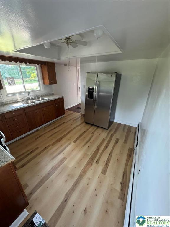 84 Moorestown Dr, Moore Twp, PA 18014 - kitchen featuring stainless steel fridge, brown cabinetry, light wood-style flooring, and light countertops