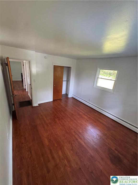 84 Moorestown Dr, Moore Twp, PA 18014 - unfurnished bedroom with a baseboard radiator, dark wood-type flooring, and a closet