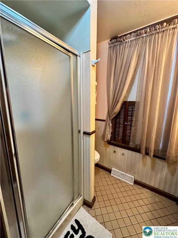 189 W 27th St, Northampton Boro, PA 18067 - bathroom with a stall shower, tile patterned floors, and wooden walls