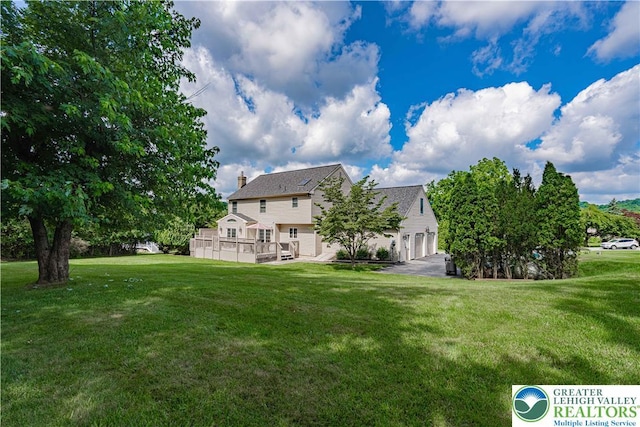 2029 Amherst Dr, Lower Saucon Twp, PA 18015 - back of property with a garage, a deck, a lawn, and a chimney