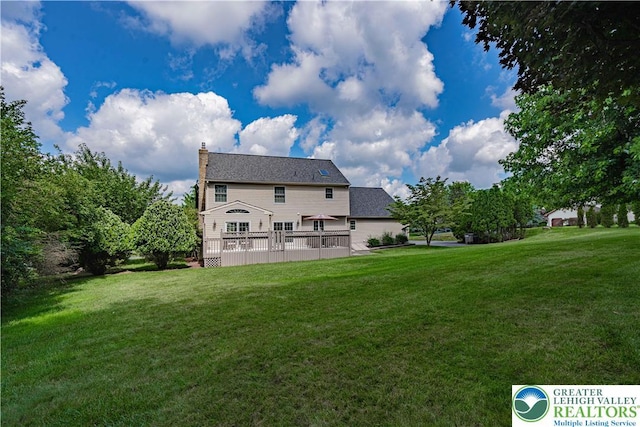2029 Amherst Dr, Lower Saucon Twp, PA 18015 - back of property featuring a lawn, a wooden deck, and a chimney