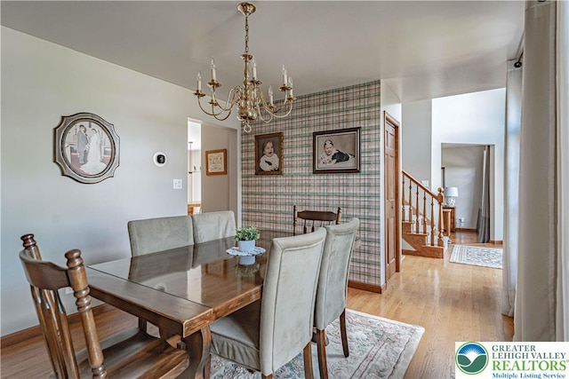 2029 Amherst Dr, Lower Saucon Twp, PA 18015 - dining room with an accent wall, a chandelier, stairway, wallpapered walls, and light wood-type flooring