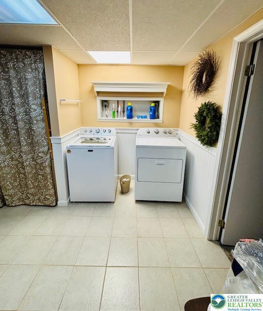 2734 Old Bethlehem Pike, Milford Twp, PA 18951 - washroom with washer and dryer, light tile patterned floors, and a wainscoted wall