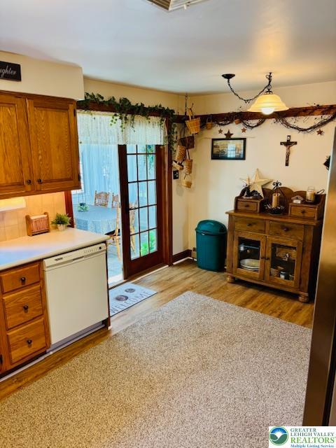 2734 Old Bethlehem Pike, Milford Twp, PA 18951 - kitchen with white dishwasher, brown cabinets, light wood-style floors, light countertops, and tasteful backsplash