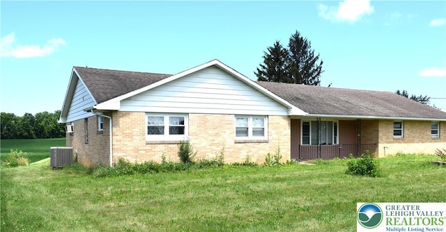 2841 Willow St, North Whitehall Twp, PA 18037 - view of side of property featuring brick siding, a lawn, a shingled roof, and a porch