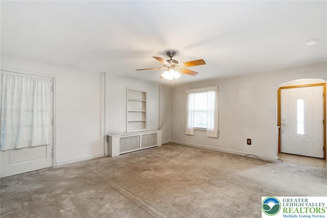 457 E Lawn Rd, Upper Nazareth Twp, PA 18064 - unfurnished living room with a ceiling fan, arched walkways, built in features, and carpet floors