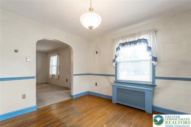 457 E Lawn Rd, Upper Nazareth Twp, PA 18064 - empty room with arched walkways, radiator, and wood finished floors