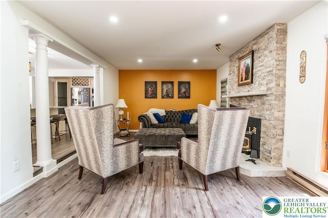 1555 Longleaf Dr, Chestnuthill Twp, PA 18330 - living area featuring a baseboard radiator, wood finished floors, decorative columns, recessed lighting, and a stone fireplace