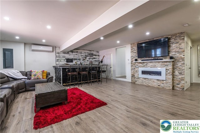 1555 Longleaf Dr, Chestnuthill Twp, PA 18330 - living room featuring electric panel, a bar, an AC wall unit, a stone fireplace, and wood finished floors