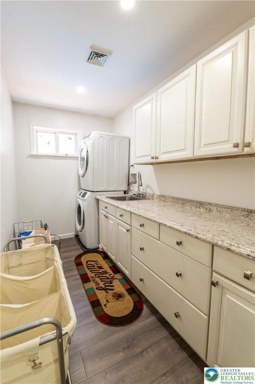 1555 Longleaf Dr, Chestnuthill Twp, PA 18330 - laundry area with stacked washer / drying machine, cabinet space, and wood finished floors