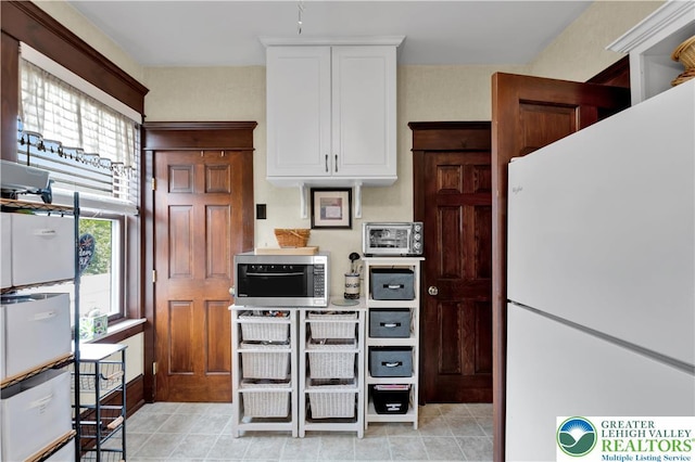 14 S 14th St, Easton, PA 18042 - kitchen featuring freestanding refrigerator, stainless steel microwave, and white cabinets