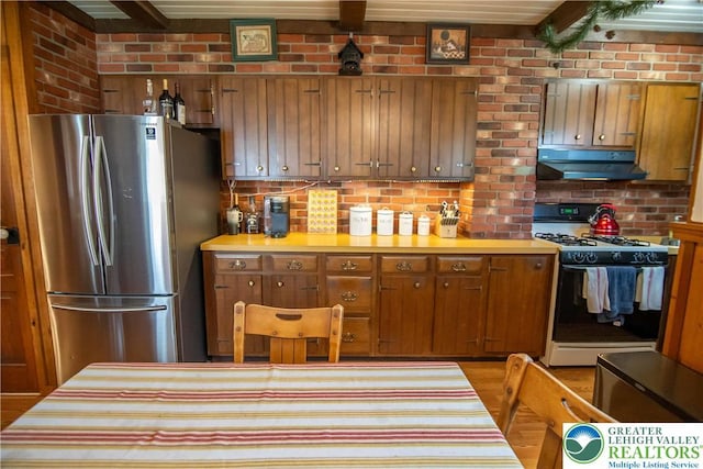 1666 Newport Ave, Northampton Boro, PA 18067 - kitchen with freestanding refrigerator, gas stove, under cabinet range hood, light countertops, and brown cabinets