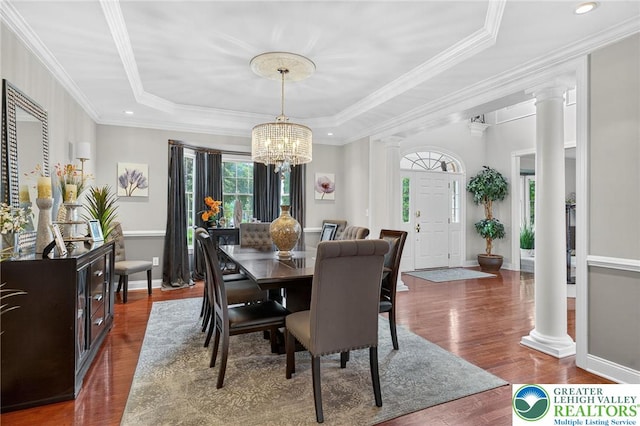 4508 Homestead Dr, Lower Nazareth Twp, PA 18064 - dining space with decorative columns, a tray ceiling, wood finished floors, a chandelier, and crown molding