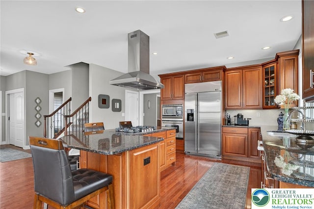 4508 Homestead Dr, Lower Nazareth Twp, PA 18064 - kitchen featuring built in appliances, island exhaust hood, a kitchen island, light wood-style flooring, and a kitchen bar