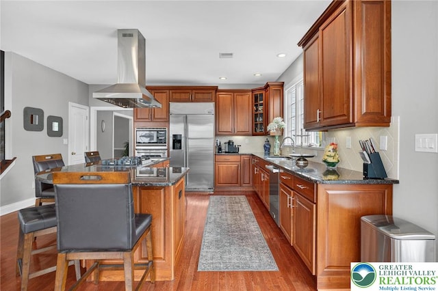 4508 Homestead Dr, Lower Nazareth Twp, PA 18064 - kitchen featuring built in appliances, island range hood, wood finished floors, brown cabinetry, and recessed lighting