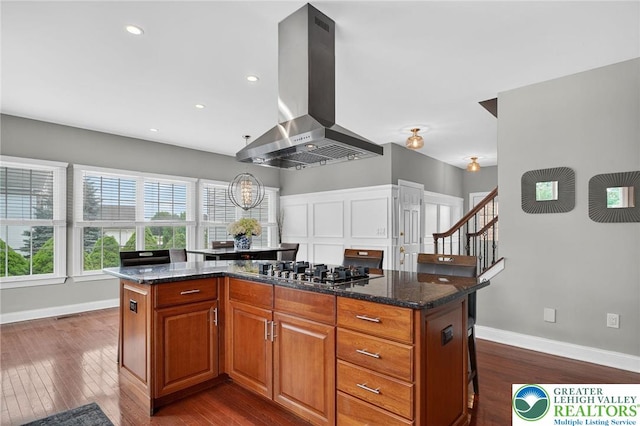 4508 Homestead Dr, Lower Nazareth Twp, PA 18064 - kitchen featuring range hood, stainless steel gas cooktop, dark wood-style flooring, a kitchen island, and dark stone counters