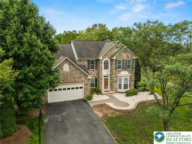 232 S 33rd St, South Whitehall Twp, PA 18104 - view of front of home with stone siding, driveway, and an attached garage