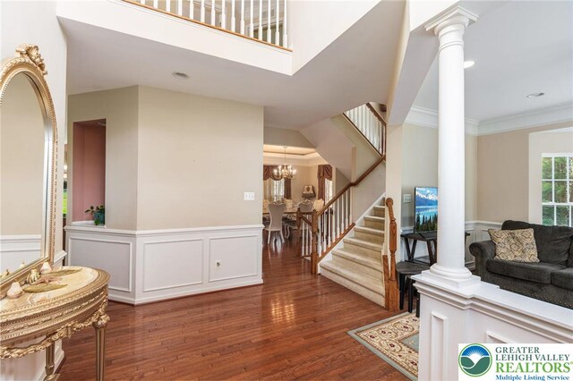 232 S 33rd St, South Whitehall Twp, PA 18104 - foyer featuring decorative columns, stairway, wood finished floors, a wainscoted wall, and ornamental molding