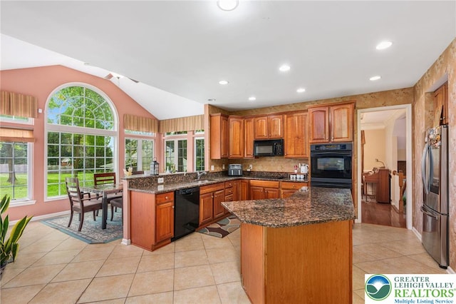 232 S 33rd St, South Whitehall Twp, PA 18104 - kitchen featuring black appliances, lofted ceiling, brown cabinets, healthy amount of natural light, and dark stone countertops