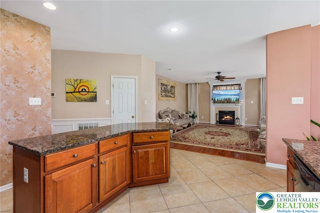232 S 33rd St, South Whitehall Twp, PA 18104 - kitchen featuring a ceiling fan, light tile patterned floors, dark stone countertops, a warm lit fireplace, and recessed lighting
